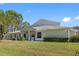 Tan house with a gray roof and lush lawn at 3203 Audubon Ct, Tarpon Springs, FL 34688