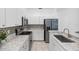 Updated kitchen showcasing stainless steel appliances, granite countertops, and white cabinetry at 3203 Audubon Ct, Tarpon Springs, FL 34688