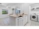 Open-concept kitchen featuring granite countertops, stainless steel sink, and adjacent laundry room for added convenience at 3203 Audubon Ct, Tarpon Springs, FL 34688