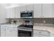 Close up of modern stainless steel appliances in a well-lit kitchen with white cabinets at 3203 Audubon Ct, Tarpon Springs, FL 34688