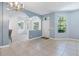 Bright open concept living room features tile floors, soft blue walls and a large window at 3203 Audubon Ct, Tarpon Springs, FL 34688