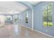 Open living room with light-blue walls, tile floors, and large windows at 3203 Audubon Ct, Tarpon Springs, FL 34688