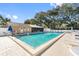 Community pool surrounded by lounge chairs, pool house, and landscaping at 3203 Audubon Ct, Tarpon Springs, FL 34688
