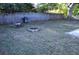 Large backyard featuring a fence, mature trees, a grill, and a fire pit at 6741 Willits Ave, New Port Richey, FL 34655