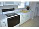 Traditional-style kitchen features white appliances, cabinets and a bright yellow sink at 6741 Willits Ave, New Port Richey, FL 34655
