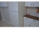 Bright kitchen with white appliances, cabinets and a wooden cabinet at 6741 Willits Ave, New Port Richey, FL 34655
