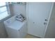 Functional laundry room with a washing machine and dryer next to a white utility door at 6741 Willits Ave, New Port Richey, FL 34655