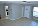 Open living space featuring neutral walls, tile flooring, and an adjacent kitchen at 6741 Willits Ave, New Port Richey, FL 34655