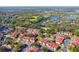 Aerial view of a community with red-roofed houses near a pool and lake at 9481 Highland Oak Dr # 807, Tampa, FL 33647