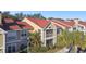 Condo building with red tile roof, and landscaping, multiple units at 9481 Highland Oak Dr # 807, Tampa, FL 33647