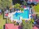 Top-down view of a community pool with surrounding lounge chairs and umbrellas at 9481 Highland Oak Dr # 807, Tampa, FL 33647