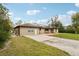 Tan single story home with solar panels, spacious yard, and a long driveway at 2609 65Th E St, Bradenton, FL 34208