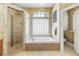 Bathroom with a large soaking tub, walk-in shower, and glass block window at 2914 Shipston Ave, New Port Richey, FL 34655