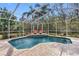 Inviting pool area with screened enclosure, lounge chairs, and brick pavers at 2914 Shipston Ave, New Port Richey, FL 34655