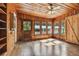 Sunroom with wood walls, wood floors, and multiple windows at 301 Old Hopewell Rd, Plant City, FL 33567