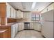 U-shaped kitchen with white cabinets, stainless steel dishwasher and appliances at 35934 Verano Ln, Zephyrhills, FL 33541