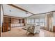 Living room with wood paneling, light floors, and large windows at 35934 Verano Ln, Zephyrhills, FL 33541