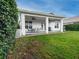 Spacious backyard with a covered patio, lush lawn, and privacy hedge at 4709 Corsage Dr, Lutz, FL 33558