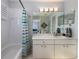 Bathroom with marble vanity, striped shower curtain, and a large mirror at 4709 Corsage Dr, Lutz, FL 33558