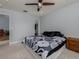Comfortable bedroom with ceiling fan, large bed, and wood nightstand at 4709 Corsage Dr, Lutz, FL 33558