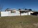 Updated single-story home with a gray exterior, new landscaping, and a driveway at 4841 Zodiac Ave, Holiday, FL 34690
