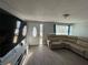Spacious living room featuring a large TV, comfortable sectional sofa, and gray vinyl plank flooring at 4841 Zodiac Ave, Holiday, FL 34690