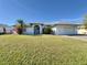 Single-story home with a large yard, attached garage, and palm trees at 491 Allworthy St, Port Charlotte, FL 33954