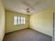 Small bedroom features yellow paint, carpet, natural light from a window, and ceiling fan at 4910 Bay Ne St # 103, St Petersburg, FL 33703