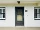 Exterior view of condo with dark door, white walls, and window shutters at 4910 Bay Ne St # 103, St Petersburg, FL 33703