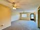 Bright living room features neutral walls, carpet, ceiling fans, and natural light from windows and front door at 4910 Bay Ne St # 103, St Petersburg, FL 33703