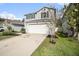 Two-story house with gray siding, white garage door, and landscaping at 7318 Sunshine Bridge Ave, Gibsonton, FL 33534