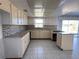 Galley-style kitchen with light cabinets and tile backsplash at 10 Golfview S Rd, Rotonda West, FL 33947