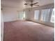 Spacious living room with pink carpet and large windows at 10 Golfview S Rd, Rotonda West, FL 33947