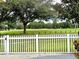 Landscaped front yard with white picket fence and golf course view at 10908 W Elbow Dr, Tampa, FL 33612