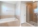 Clean bathroom with a shower, garden tub and tile flooring at 13167 Royal Pines Ave, Riverview, FL 33579