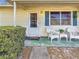 Inviting front porch with white wicker chairs and a well-manicured lawn at 1517 Young Ave, Clearwater, FL 33756