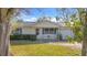 Light beige single story home with a well-maintained lawn and shrubs at 1517 Young Ave, Clearwater, FL 33756