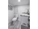 Small bathroom with toilet and vanity, features gray wood-look flooring at 415 21St N St, St Petersburg, FL 33713