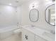Modern bathroom with double vanity, bathtub, and marble tile at 4226 Elwood Rd, Spring Hill, FL 34609