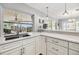 Modern kitchen with white cabinets, quartz countertops and a view to the pool at 8009 Brighton Dr, Port Richey, FL 34668