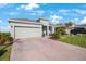 Charming single-story home featuring a two-car garage, brick-paved driveway, and neatly landscaped front yard at 11312 Gallatin Trl, Parrish, FL 34219