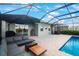 Outdoor living space featuring a screened pool, patio with a grill, and ample seating for entertainment and relaxation at 11312 Gallatin Trl, Parrish, FL 34219