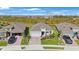 A sunny aerial view of modern single-Gathering homes featuring manicured lawns and brick paved driveways in a Primary-planned community at 11312 Gallatin Trl, Parrish, FL 34219