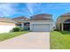 House exterior with a two-car garage and driveway, surrounded by a manicured lawn at 13419 Lake Monroe Pl, Riverview, FL 33579