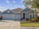 Gray two-story house with stone accents, two-car garage, and landscaped yard at 1753 Montgomery Bell Rd, Wesley Chapel, FL 33543