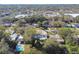 Aerial view of a house with pool, surrounded by lush trees and other homes at 1829 West Dr, Clearwater, FL 33755