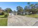 Front view of a Ranch style home with a large driveway and mature trees at 1829 West Dr, Clearwater, FL 33755