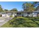 Newly renovated Ranch home with a light green exterior and a well-maintained lawn at 1829 West Dr, Clearwater, FL 33755