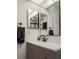 Bathroom features gray vanity, a modern mirror, and black fixtures at 3077 Branch, Clearwater, FL 33760