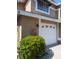 Attached garage with white door and lush green shrubs at 3077 Branch, Clearwater, FL 33760